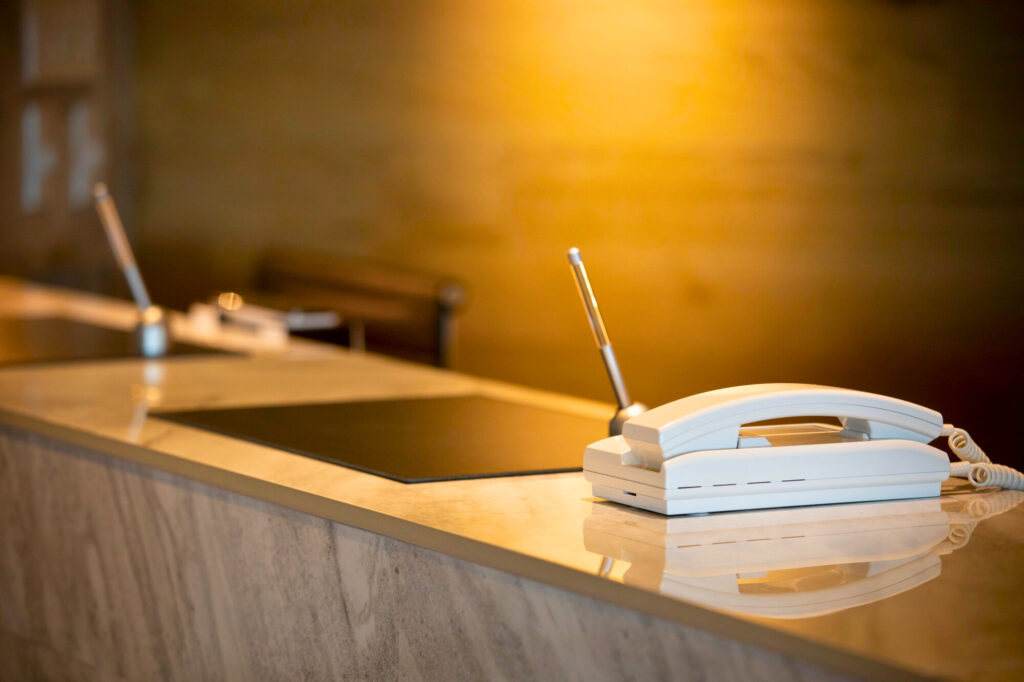 ホテルのフロントに電話機のあるイメージ